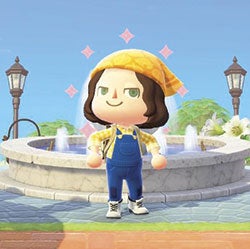Deena wearing scarf and overalls in front of fountain