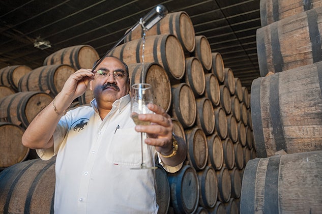 Arturo López Boites checks the sugar level and the progress of fermentation in a tank. 