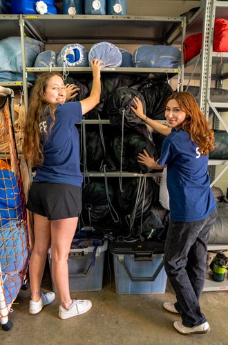 Photo of ROPE student workers organizing sleeping bag rentals