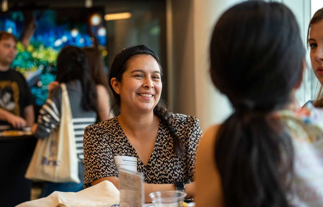Photo of grad students talking with each other at a social gathering