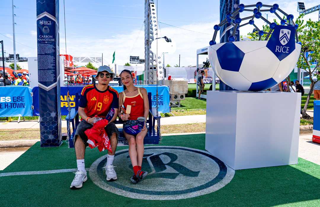 Photo of a couple sitting on swing with world cup fan gear on