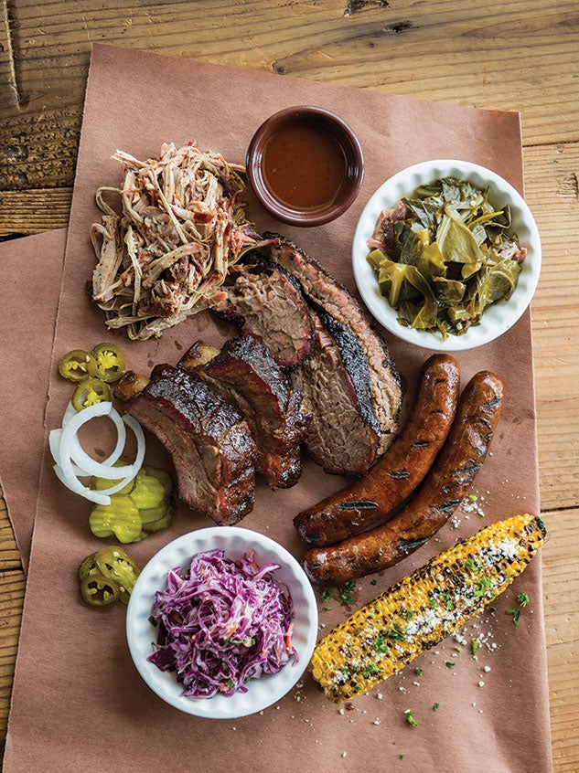 A sampling from Gatlin’s BBQ: pulled pork (see recipe below), brisket, ribs, venison sausage, coleslaw, grilled corn with Cojita cheese and collard greens. Photo by Tommy LaVergne