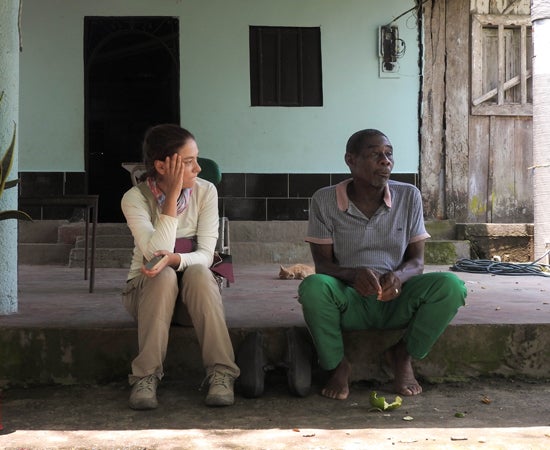 Photo of Alejandra Osejo Varona interviewing a fisherman
