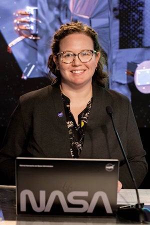 Photo of Sarah Frazier at her laptop with NASA sticker emblazoned on the laptop