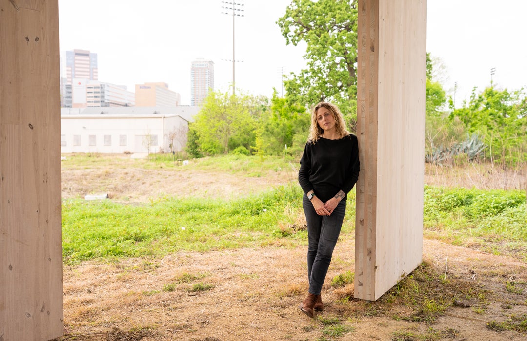 Photo of Lacy Johnson posing under the Johnson Owl Deck on campus