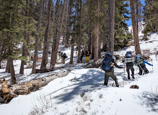 Students hiking through snow at Pecos Wilderness in New Mexico