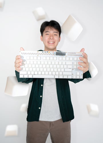 Philip Tran holds one of his mechanical keyboards