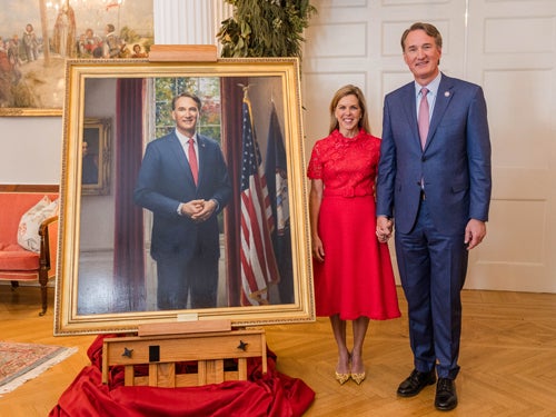 Photo of Gov. Glenn Youngkin and first lady Suzanne Youngkin next to a painting of Glenn's portrait
