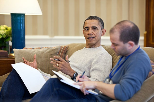 President Barack Obama watches Deputy National Security Advisor Ben Rhodes edit a speech on Air Force One, December 2013. Photo by Pete Souza