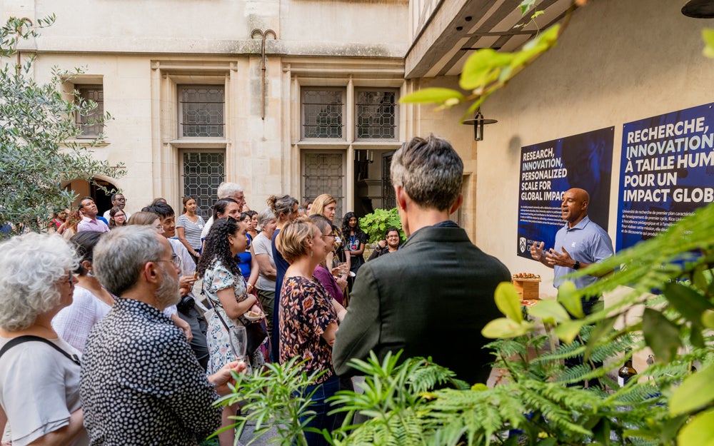 Photo of president Reginald DesRoches speaking at a reception in the garden