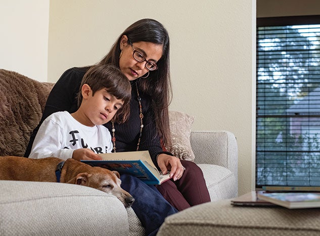 Lorena Gauthereau ’04 reads with her son, Travis. Photo by Jeff Fitlow