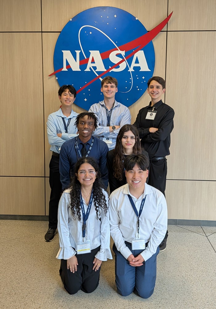 Group photo of Rice students standing in front of the NASA logo at Johnson Space Center