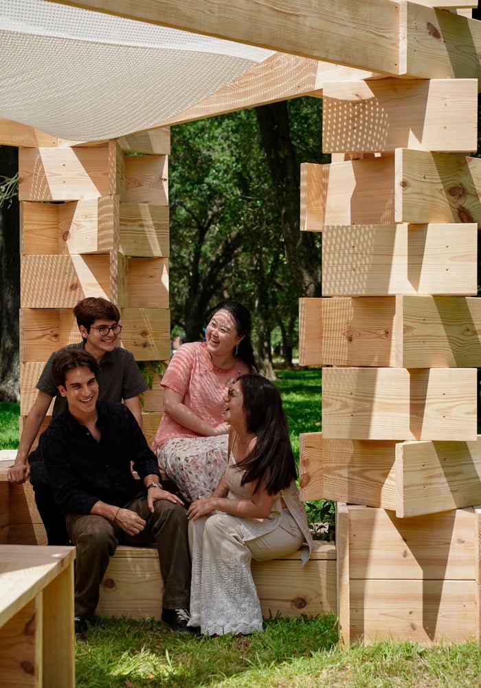 Photo of students sitting inside a structure within the university’s oak grove near Entrance 1