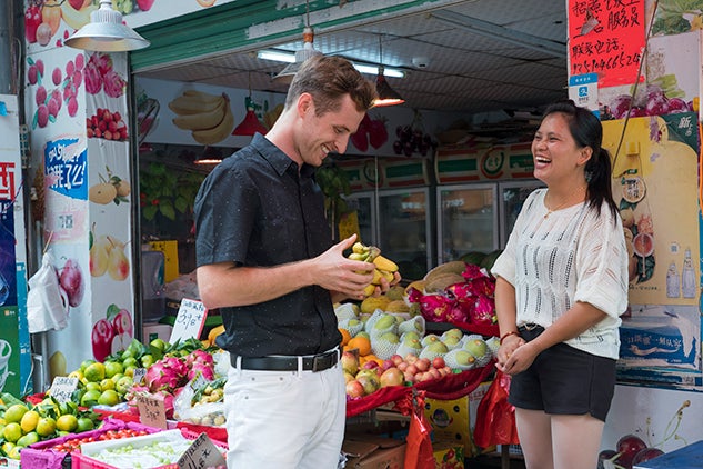 Stopping by this neighborhood fruit stand to visit Mrs. Peng has become a daily ritual for Zach Bielak. Photo by Theodore Kaye