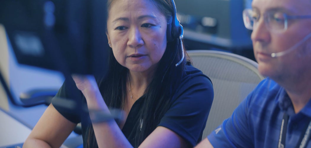 Action photo of Quyen Jones in the control room alongside a colleague pointing at a screen