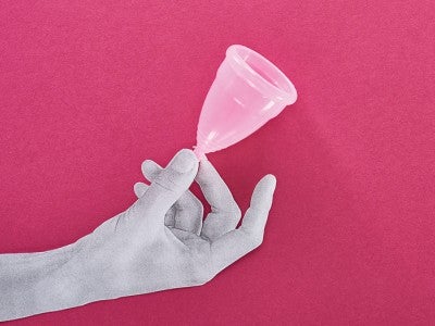 Hand holds a menstrual cup