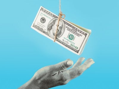Image of hand trying to grasp 100 dollar bills from a rope