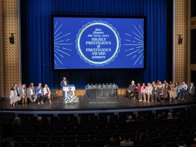 Photo of President Reginald DesRoches on stage with faculty during formal awards ceremony at Brockman Hall for Opera
