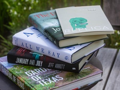 Photo of a stack of featured alumni books in the academic quad